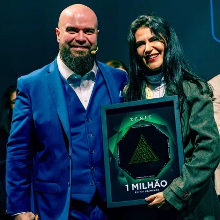 Dra. Helena ao lado do Dr. Felipe Hurtado, segurando a placa de 1 milhão em faturamento do ZENIT